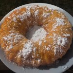 Closeup of Bundt Cake with Powdered Sugar on White Plate